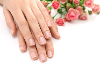 Woman hands with beautiful manicure and roses isolated on white background