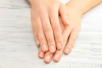 Woman hands with beautiful manicure on wooden background