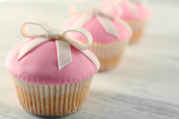 Tasty cupcakes with bow,  on light background