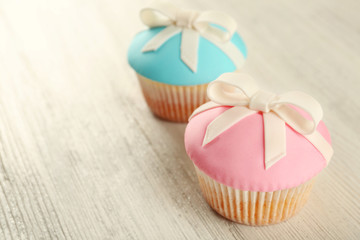 Tasty cupcakes with bow on grey background