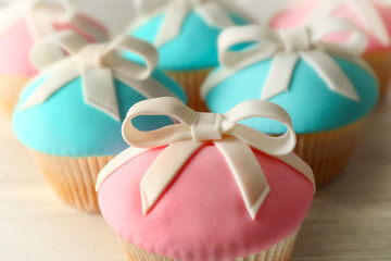 Tasty cupcakes with bow on grey background
