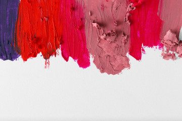 Smudged colourful lipstick on white background, close up