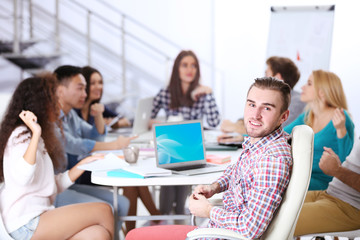 Young colleagues sitting at the business meeting in the office