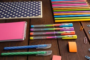 School set with notebooks, colored pens and pencils on wooden background