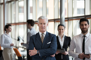 portrait of senior businessman as leader  with group of people i