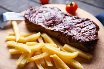 Grilled steak with french fries and cherry tomatoes, closeup