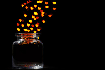 Miracle of love from glass jar on black background