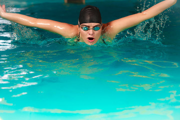 Fototapeta na wymiar Woman athlete swimming butterfly stroke in pool.
