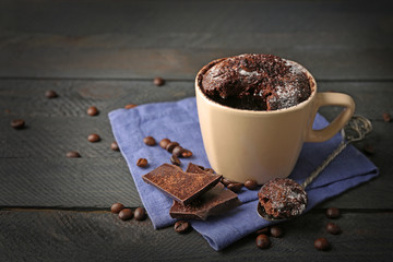 Chocolate fondant cake in cup on wooden background