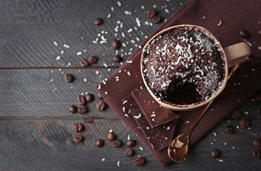 Chocolate fondant cake in cup on wooden background