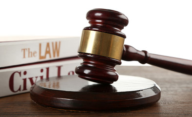 Gavel and books on wooden table on white background