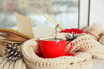 Cup of hot drink in on the windowsill in living room. Comfortable winter weekend or holidays at home