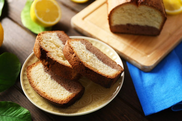 Delicious sweet cake bread with lemons on wooden table closeup