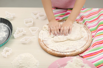Beautiful little girl rolling the dough.
