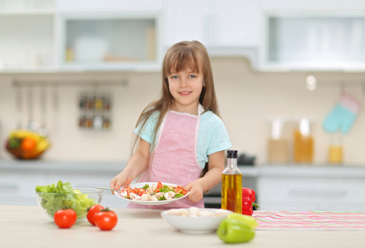 Little girl with a plate of vegetable salad.