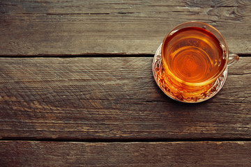 Glass cup of tea on wooden background