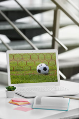 Stylish workplace with laptop, flower and notebook in office