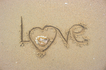 Write love wrote on the sand.