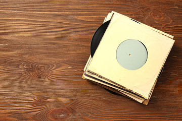 Stack of old vinyl records on wooden background