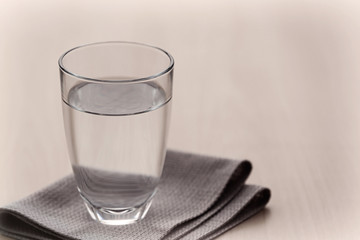 Glass of pure water on light wooden table