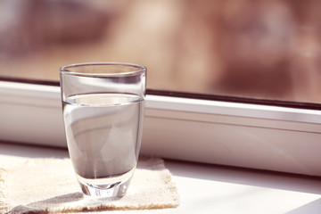 Glass of pure water on windowsill