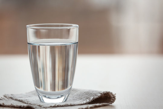 Glass of pure water on blurred background