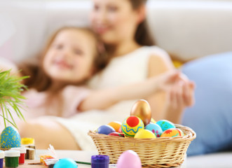 Obraz na płótnie Canvas Wicker basket with colorful Easter eggs closeup
