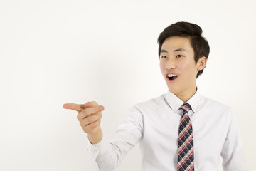 Asian young businessman pointing and laughing at someone or something 