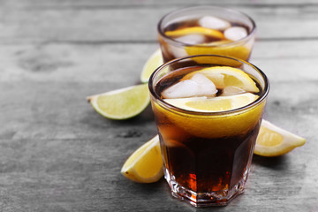 Glasses of soda water with sliced lemon on wooden table