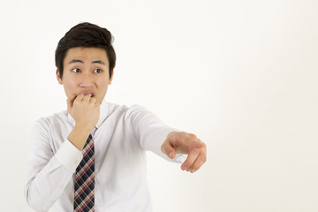 Young asian businessman covering his mouth and pointing at someone or something