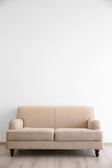 Cozy couch on wall background