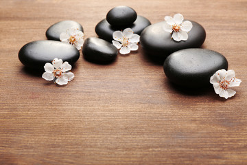 Fototapeta na wymiar Heap of spa hot stones on wooden background