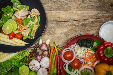 Pork, salad and lemon on a plate with vegetables and spices to c