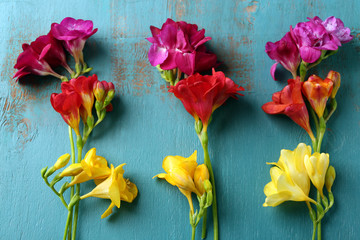 Beautiful freesia flowers on wooden background