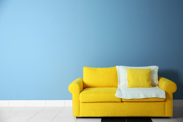 Yellow sofa on blue wall background