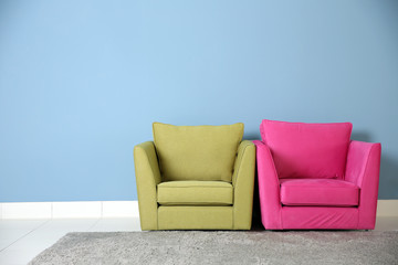 Two armchairs on blue wall background