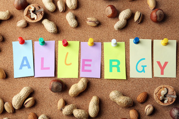 Word ALLERGY with nuts on cork board