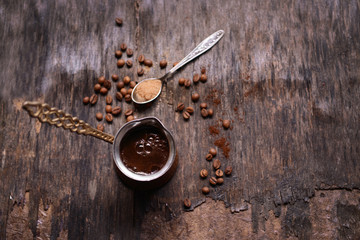 Turk of coffee with beans on wooden table