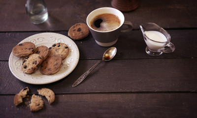 Cup of coffee with cookies on wooden table