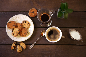 Cup of coffee with cookies on wooden table
