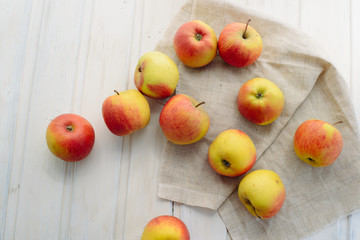 apples on a white rag on the gray wooden background top view, rustic concept