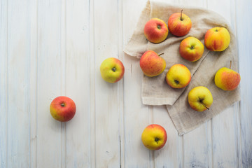 apples on a white rag on the gray wooden background top view, rustic concept
