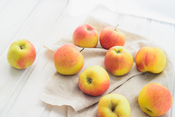 apples on a white rag on the gray wooden background top view, rustic concept