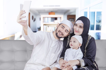 Fototapeta premium Arabic parents and their son taking selfie photo