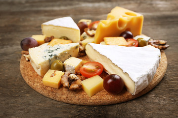 Different kinds of cheese on wooden background