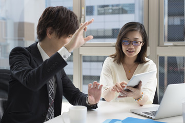Business people are talking in the office while watching the tablet
