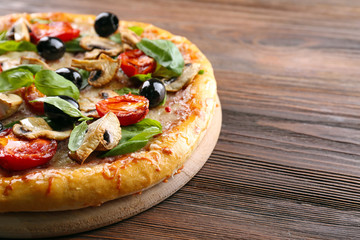 Delicious tasty pizza with ingredients on wooden table