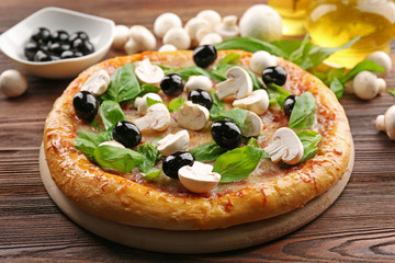 Delicious tasty pizza with ingredients on wooden table