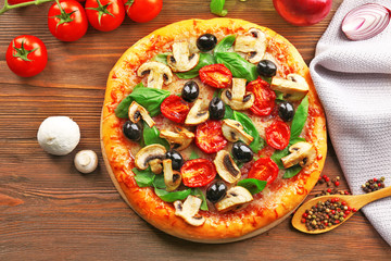 Delicious tasty pizza with ingredients on wooden table
