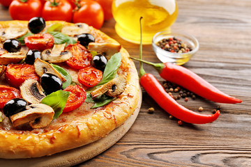 Delicious tasty pizza with ingredients on wooden table